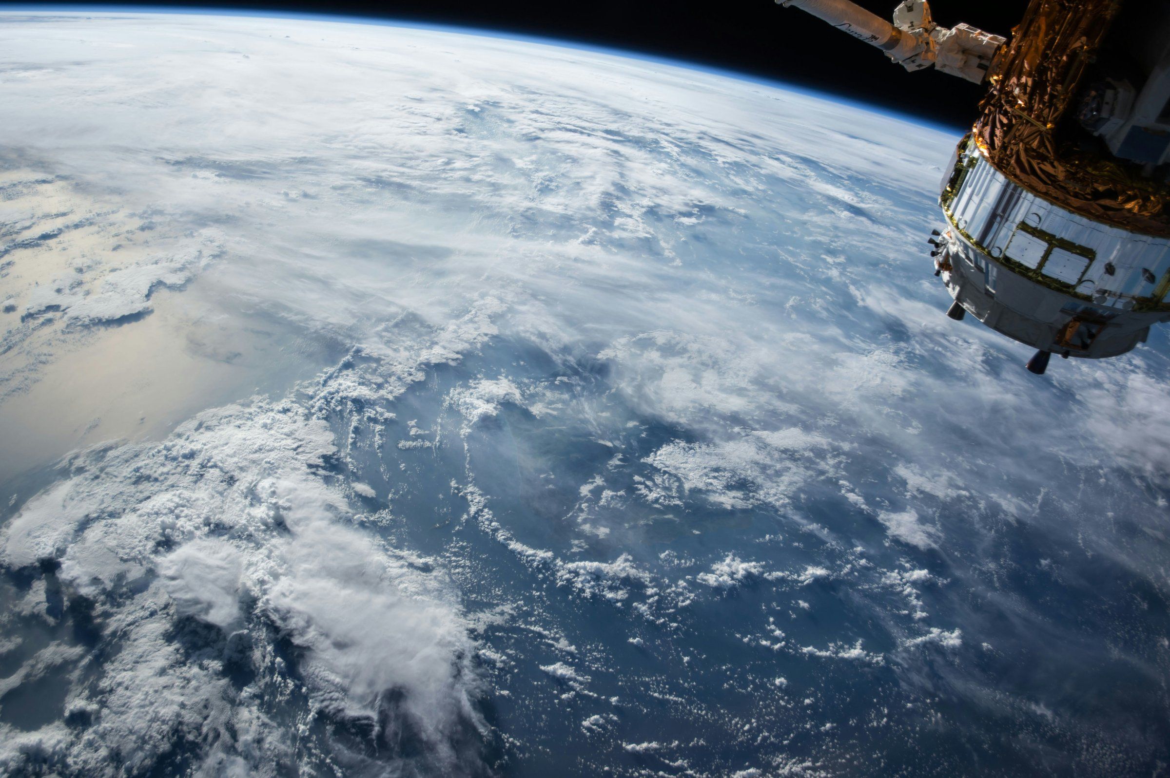 The Earth under cloud, seen from orbit beside a spacecraft